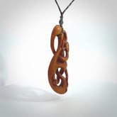 This necklace is carved from cow bone and stained with a homemade tea dye. It is a unique piece of wearable art that is sure to catch the eye. The shape is a complex twist form and has been beautifully hand carved by bone carver Yuri Terenyi.